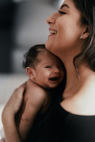 抱着微笑婴儿的女人
